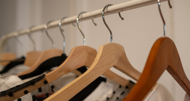 Clothes evenly spaced on a clothing rack